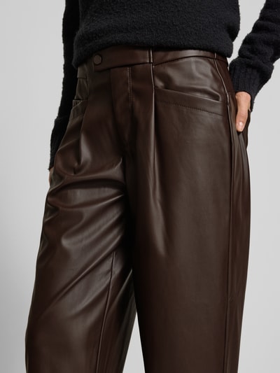 Männermodel trägt braune Wide Leg Kunstlederhose mit Bundfalten von Buena Vista, glatte Textur, Nahaufnahme Oberkörper