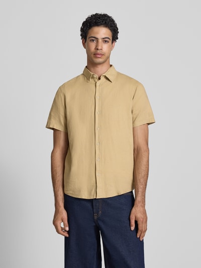 Männermodel trägt Slim Fit Leinenhemd mit Viskose-Anteil Modell 'Bobby' von Blend, Kentkragen, kurzärmelig, beige, Ganzkörperansicht von vorne.