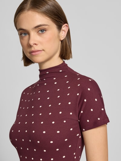 Vrouwenmodel draagt Slim Fit T-Shirt aus Baumwoll-Mix van Marc O'Polo DENIM, bordeaux met witte stippen, zachte ribtextuur, close-up bovenlichaam.
