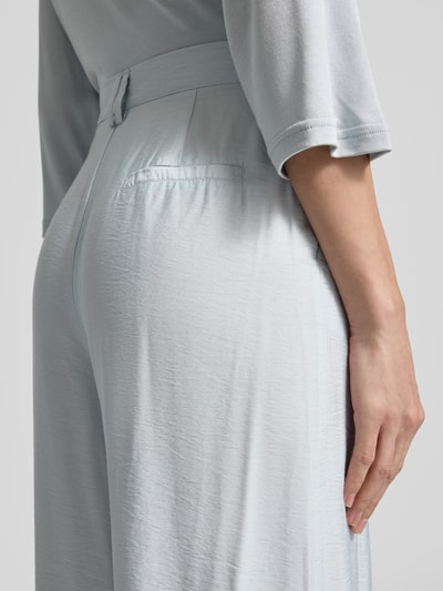 Frauenmodel trägt Wide Fit Stoffhose Modell 'FINJA' von GUIDO MARIA KRETSCHMER WOMAN aus fließendem Stoff in Hellblau mit Eingrifftaschen, Detailaufnahme Rückansicht, Bundweite bei Größe 36: 36 cm, Innenbeinlänge: 78 cm.