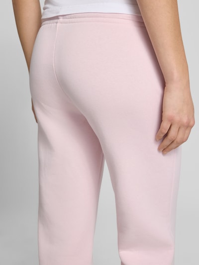 Frauenmodel trägt Sweatpants mit elastischem Bund Modell 'Iconic' von Gina Tricot, rosa Farbton, Baumwoll-Mix, Relaxed-Fit, Detailaufnahme Rückansicht. Damen Sweatpants, Innenbeinlänge bei Größe S: 80 cm.