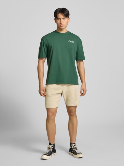 Męski model nosi Shorts mit Label-Patch Modell 'LIBCO' od Pegador, wzór strukturalny, beżowy, prosty krój, materiał z bawełną, elastyczny pas, zdjęcie całej sylwetki z przodu