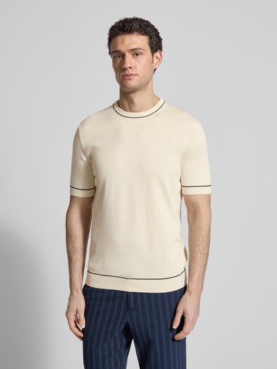 Männermodel trägt Strickshirt mit Rundhalsausschnitt von Gant in Creme mit schwarzen Akzenten, gerader Schnitt, Baumwoll-Modal-Mix, Nahaufnahme Oberkörper.