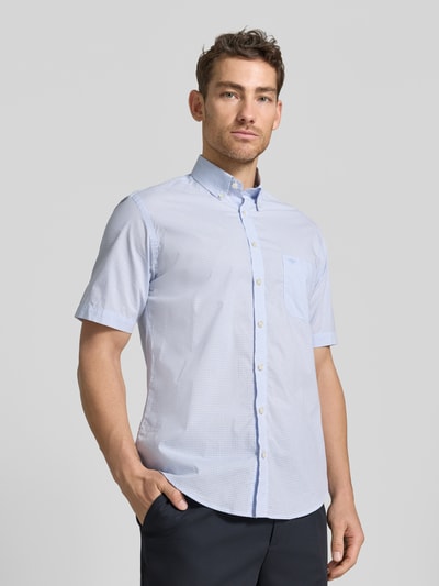 Männermodel trägt Modern Fit Freizeithemd mit Brusttasche und Logo-Stitching von Fynch-Hatton, feines hellblau kariertes Muster, reine Baumwolle, Button-Down-Kragen, Knopfleiste, abgerundeter Saum, Ganzkörperansicht von vorne.