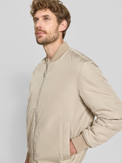 Männermodel trägt Regular Fit Bomberjacke mit Baseball-Kragen Modell 'CHARLES' von Selected in Beige, Nahaufnahme Oberkörper. Herren Bomberjacke.