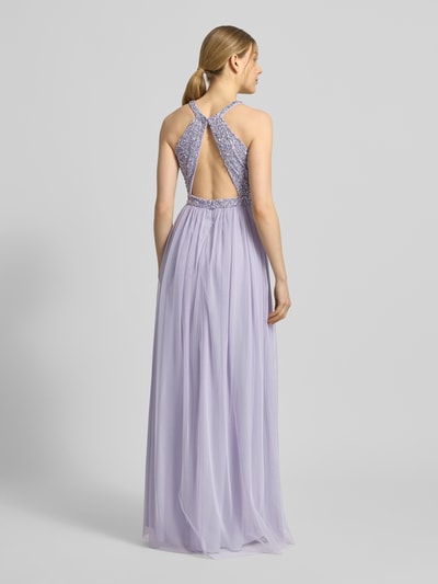 Frauenmodel trägt Abendkleid mit Strasssteinbesatz und Rundhalsausschnitt von Jake*s Cocktail in zartem Flieder, Chiffon, A-Linie, Maxikleid, mit rückseitigem Cut Out und Reißverschluss, Ganzkörperansicht Rückansicht.