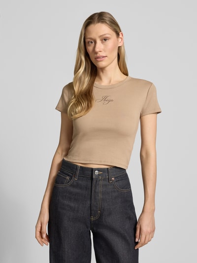 Kobiece modelka nosi Slim Fit T-Shirt aus Baumwoll-Mix Modell 'DELANOR' von HUGO, efekt: jednolity kolor, okrągły dekolt, wyhaftowane logo, krótki rękaw, wykończenie materiału: dżersej, materiał: mieszanka bawełny, z przodu, zbliżenie na górną część ciała