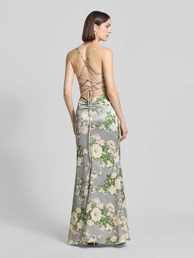 Vrouwenmodel draagt avondjurk met rückseitiger Schnürung van Mascara in glanzend satijn met groen-witte bloemenprint, nauwsluitend model, maxi-jurk, cascadehals, rugdecolleté met gekruiste spaghettibandjes en drapering, ruglengte maat 36: 134 cm, borstwijdte maat 36: 33 cm. Ganzlichaamsaanzicht achteraan.