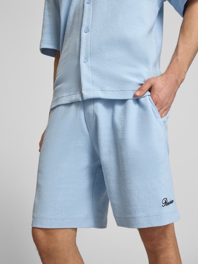 Mężczyzna nosi szorty z wyhaftowanym logo o fakturowanym wzorze, mieszanka bawełny, krój regular fit, Shorts mit Label-Stitching von REVIEW, szerokość w rozmiarze M: 42 cm, długość wewnętrzna nogawki w rozmiarze M: 22 cm, zbliżenie na dolną część ciała.