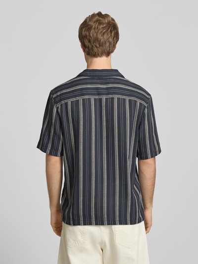Männermodel trägt Relaxed Fit Freizeithemd mit Logo-Stitching von REVIEW, dunkelblau mit hellen Streifen, Rückenansicht, Ganzkörperansicht Rückansicht. Rückenlänge 69 cm, Schulterbreite 49 cm, Ärmellänge 27 cm, Reverskragen und Knopfleiste, strukturierte Stoffoptik.