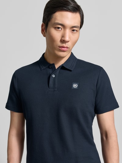 Männermodel trägt Regular Fit Poloshirt mit Label-Detail und Knopfleiste von Lerros, Reine Baumwolle, marineblau, Nahaufnahme Oberkörper.