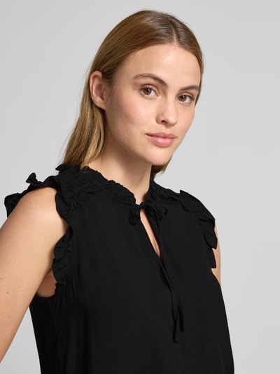 Kobiece model prezentuje Regular Fit Blusentop aus reiner Viskose Modell 'ALBA' od Vero Moda, czarny, gładki, bez rękawów, marszczony kołnierz, detal wiązany, krój regular fit, materiał wiskozowy, zbliżenie na górną część ciała.