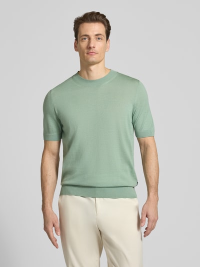 Männermodel trägt Regular Fit Strick-Shirt aus reiner Schurwolle Modell 'H-UMAURO' von BOSS, mintgrün, unifarben, Ganzkörperansicht von vorne.
