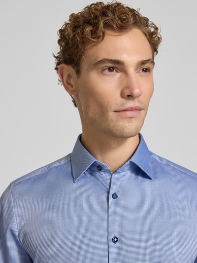 Männermodel trägt Body Fit Businesshemd aus Baumwoll-Mix von OLYMP, feines blaues Muster, glatte Textur, Nahaufnahme Oberkörper, Herren Businesshemd von OLYMP Level 5