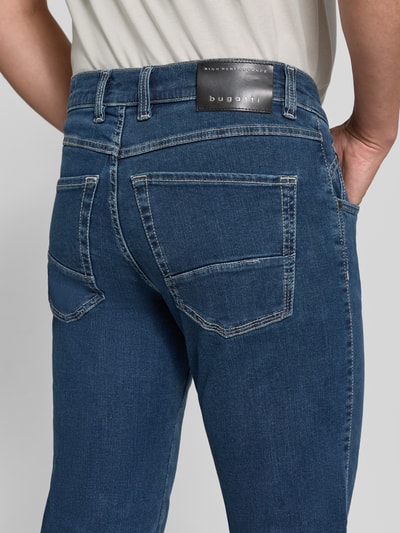 Mężczyznamodel nosi Regular Fit Jeans im 5-Pocket-Design von bugatti z mieszanka bawełny, zapięcie na guzik i zamek błyskawiczny, szerokość w rozmiarze 32/32: 43 cm, długość wewnętrzna nogawki w rozmiarze 32/32: 82 cm, widoczna faktura materiału, niebieski kolor, detaliczne przeszycia, detalaufnahme tyłu.