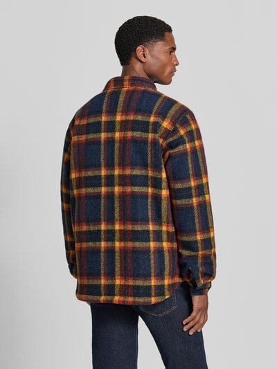 Männermodel trägt Regular Fit Freizeithemd Modell 'Hunter Arch™' von Columbia mit Karomuster in Gelb, Rot und Blau, Rückenansicht.