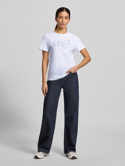 Frauenmodel trägt T-Shirt mit Label-Detail von Liu Jo White aus reiner Baumwolle, Slim Fit, weiße Farbe, Ganzkörperansicht von vorne.