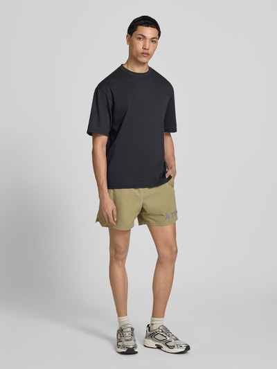 Männermodel trägt Shorts mit elastischem Bund und Label-Print von HALO in Beige, Material-Mix mit Stretch, Regular Fit, Ganzkörperansicht von vorne.