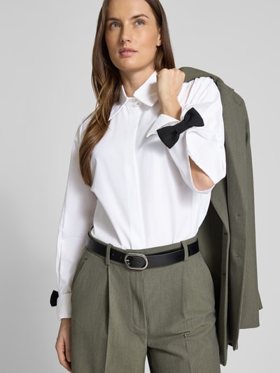 Frauenmodel trägt Hemdbluse mit Knopfleiste von Marella, reine Baumwolle, lockerer Schnitt, weiß, Nahaufnahme Oberkörper.