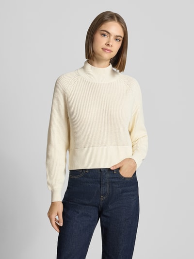 Frauenmodel trägt Regular Fit Pullover Baumwoll-Mix Modell 'Dara' von NOISY MAY®, cremefarben, Strick-Optik, Stehkragen, Ganzkörperansicht von vorne.
