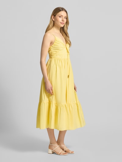 Frauenmodel trägt Midikleid mit Volantsaum und V-Ausschnitt von MICHAEL Michael Kors, Reine Baumwolle, A-Linie, Ganzkörperansicht von vorne.