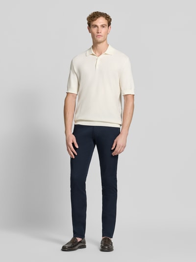 Männermodel trägt Skinny Fit Jeans aus Baumwoll-Mix von Emporio Armani in Dunkelblau, 5-Pocket-Design, Ganzkörperansicht von vorne.