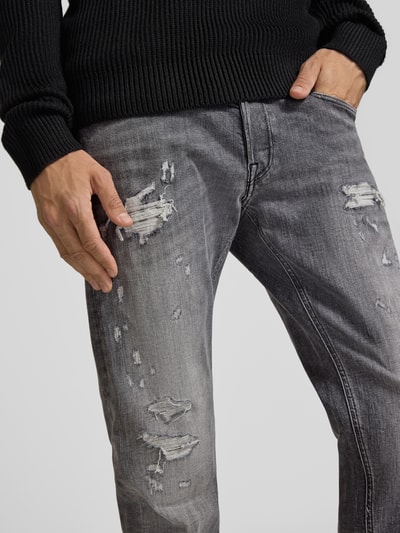 Männermodel trägt Straight Fit Jeans im Used-Look Modell 'Grover' von Replay, Baumwoll-Mix, graue Waschung, Nahaufnahme Oberkörper, Kontext wie angegeben.