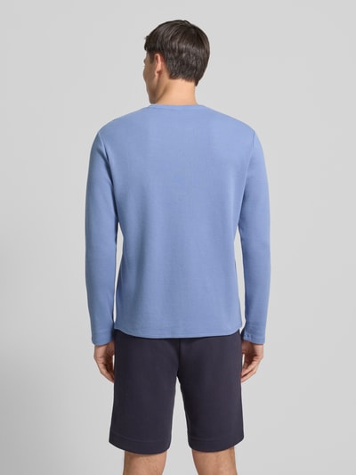 Męski model nosi Regular Fit Langarmshirt aus Baumwoll-Mix od BOSS, niebieski, struktura waflowa, prosty krój, widok całej sylwetki z tyłu.