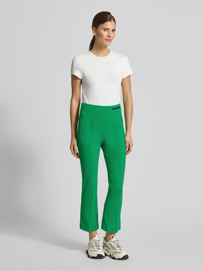 Frauenmodel trägt Loose Fit Jogpants mit breitem Bund von Marc Cain in Grün, Elastischer-Material-Mix, Reißverschlusstasche, Ganzkörperansicht von vorne.