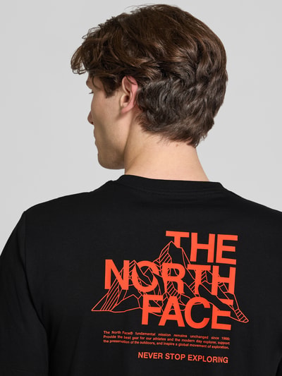Männermodel trägt T-Shirt mit Logo und Rundhalsausschnitt van The North Face in zwart katoenmix, regular fit, ruglengte maat M 72 cm, Ganzkörperansicht Rückansicht