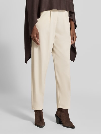 Frauenmodel trägt Relaxed Fit Anzughose mit Bundfalten Modell 'SC-SIHAM 103' von Soyaconcept in Creme, glatte Textur, Nahaufnahme Unterkörper, Damen Anzughose von Soyaconcept.