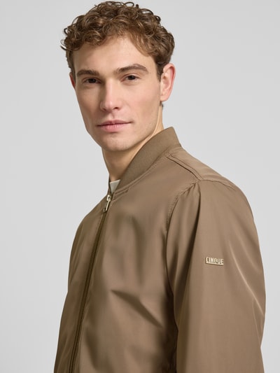 Männermodel trägt Regular Fit Jacke mit Stehkragen Modell 'Rapid' von CINQUE in beige, glatte textur, Nahaufnahme Oberkörper, heren jack van CINQUE, regular fit, tweeweg ritssluiting, elastische boorden, ruglengte maat M 69 cm, schouderbreedte 46 cm, borstwijdte 55 cm, mouwlengte 70 cm