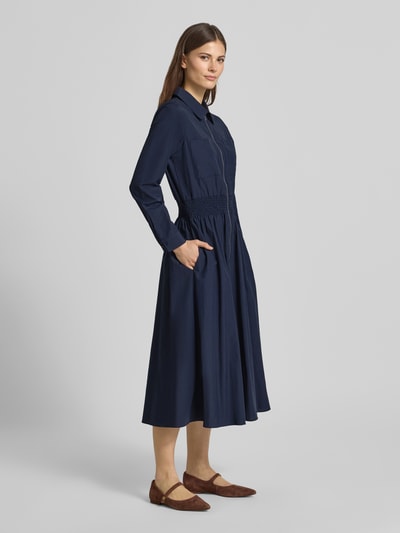 Modelka nosi sukienka koszulowa z mieszanka bawełny, linia a, sukienka midi z zamkiem błyskawicznym Soyaconcept Hemdblusenkleid mit Reißverschluss Modell 'NETTI', elastycznym tasiemką w talii; długość tyłu w rozmiarze S: 121 cm, szerokość w rozmiarze S: 42 cm, długość rękawów w rozmiarze S: 60 cm; kolor granatowy, gładka tekstura; widok całej sylwetki z przodu.