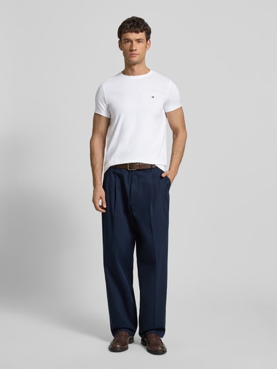 Männermodel trägt Slim Fit T-Shirt mit Rundhalsausschnitt von Tommy Hilfiger aus Baumwoll-Elasthan-Mix, Logo-Stickerei, Ganzkörperansicht von vorne.