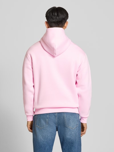 Männermodel trägt Hoodie mit Känguru-Tasche von REVIEW in Rosa, Baumwollmischung, lockere Passform, Ganzkörperansicht Rückansicht.