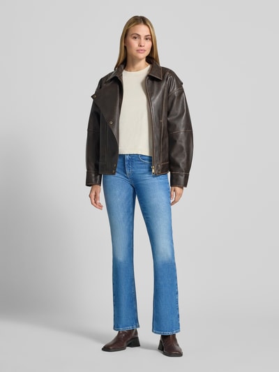 Frauenmodel trägt blaue Bootcut-Jeans aus Baumwoll-Mix Modell 'MARY' von Brax, helle Waschung, Damen Bootcut-Jeans, Ganzkörperansicht von vorne.