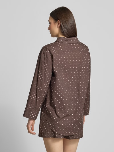 Frauenmodel trägt Relaxed Fit Bluse im Allover-Look Modell 'FRIDA' von Noisy May in Braun mit weißen Punkten, Material-Mix, Hemdblusenkragen, Brusttasche, Label-Detail, Rückenlänge 76 cm, Ärmellänge 52 cm, Ganzkörperansicht Rückansicht.