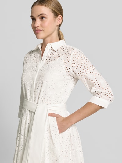 Frauenmodel trägt Hemdblusenkleid aus Lochspitze mit Knopfleiste von Milano Italy, weiße Baumwolle, taillierte Passform, Nahaufnahme Oberkörper.