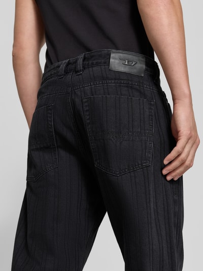 Männermodel trägt Straight Fit Jeans mit Viskose-Anteil von Diesel, dunkler Baumwoll-Mix, 5-Pocket-Design, Logo-Detail, Ganzkörperansicht Rückansicht.