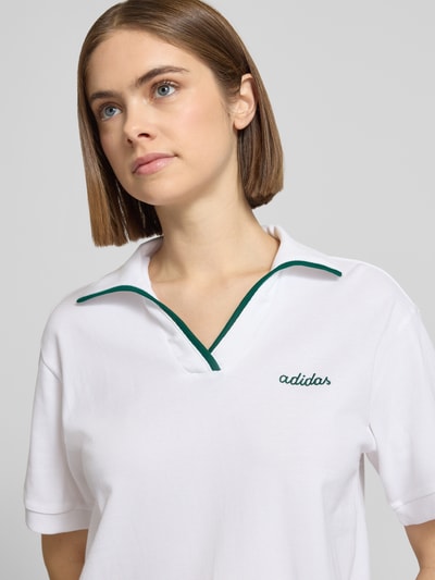 Frauenmodel trägt Regular Fit Poloshirt mit Logo-Stitching von adidas Sportswear in Weiß, reine Baumwolle, Polo-Kragen, Nahaufnahme Oberkörper.