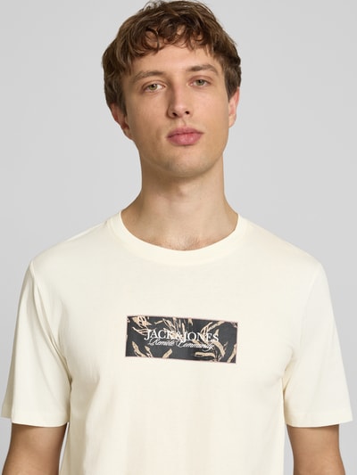 Männermodel trägt T-Shirt mit Label-Print von Jack & Jones in Creme, Reine Baumwolle, Gerader-Schnitt, Rundhalsausschnitt, Nahaufnahme Oberkörper.