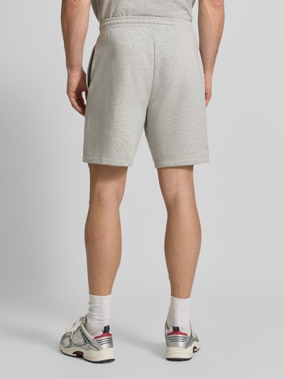 Männermodel trägt hellgraue GAP Straight Fit Shorts mit Logo-Stitching, Baumwoll-Mix, elastischer Bund, Ganzkörperansicht Rückansicht.