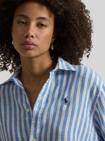 Frauenmodel trägt Boxy Fit Hemdbluse aus reinem Leinen von Polo Ralph Lauren mit blau-weißem Allover-Streifenmuster, Logo-Stitching, Nahaufnahme Oberkörper.
