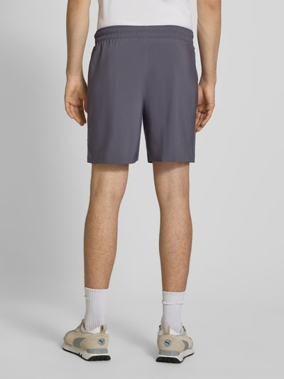 Männermodel trägt Shorts mit Logo und elastischem Bund von PUMA PERFORMANCE in Grau, Regular Fit, elastischer Bund, Ganzkörperansicht Rückansicht.