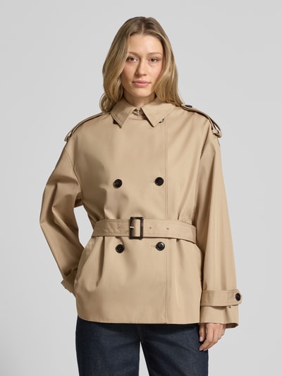 Modelka kobieca ma na sobie Regular Fit Trenchcoat aus reiner Baumwolle od Tommy Hilfiger, kolor jednolity, krój regular fit, dwurzędowy zapięcie na guziki, pasek w talii z klamrą, logo, pagony, długi rękaw z paskiem, kieszenie boczne, twill z czystej bawełny, widok całego ciała z przodu.