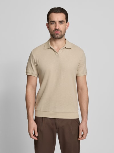 Męski model nosi Comfort Fit Poloshirt mit V-Ausschnitt od Lindbergh z bawełny, fakturowany wzór, detal z logo, długość tyłu w rozmiarze M: 68 cm, całkowity widok z przodu.