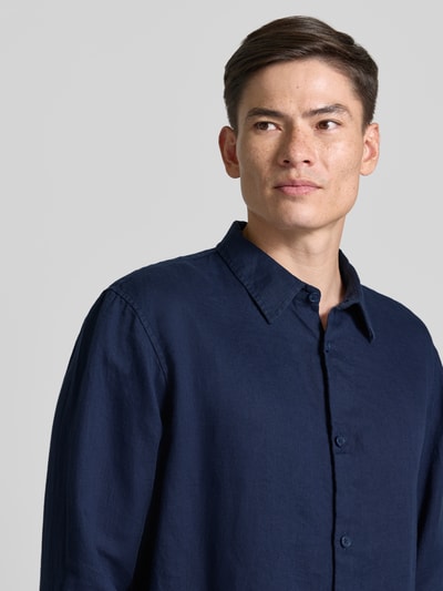 Männermodel trägt Regular Fit Leinenhemd mit Kentkragen von GAP, dunkelblau, reine Leinen, Knopfleiste, Nahaufnahme Oberkörper.