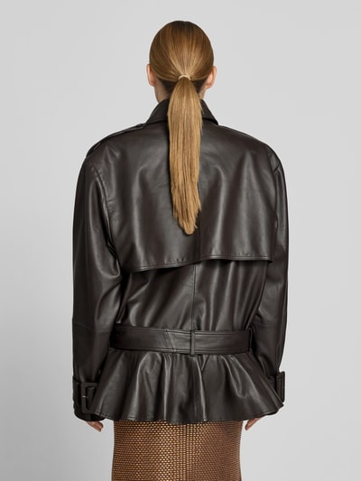 Frauenmodel trägt Oversized Jacke aus echtem Lammleder von ROTATE, Umlegekragen, integrierter Gürtel, Knopfverschluss, Rückenlänge 76 cm, Brustweite 67 cm, Ärmellänge 67 cm, schwarze Farbe, glatte Lederstruktur, Ganzkörperansicht Rückansicht.