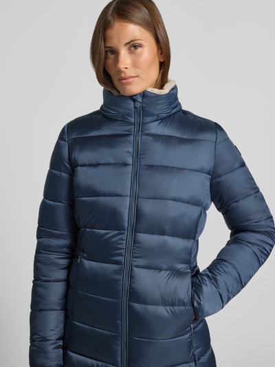 Frauenmodel trägt Steppmantel mit abnehmbarer Kapuze Modell 'CLELIA' von Save The Duck in Blau, glatte Oberfläche, Nahaufnahme Oberkörper.
