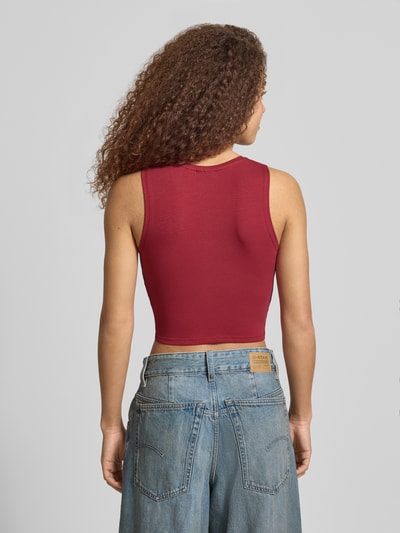 Młodzieżowy top Crop Top mit Knotendetail Modell 'TWIGGI' von Noisy May, mieszanka bawełny z dodatkiem streczu, krój krótki, okrągły dekolt, wiązany detal, długość tyłu w rozmiarze S: 37 cm, kobiecy model, widok całej sylwetki z tyłu.